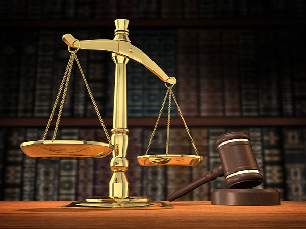 Scales of justice and gavel on desk with dark background that allows for copyspace.